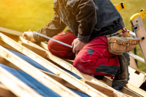 Craftsman or construction worker install a new roof, roofing tools, new metallic roof or metal sheet, building concept